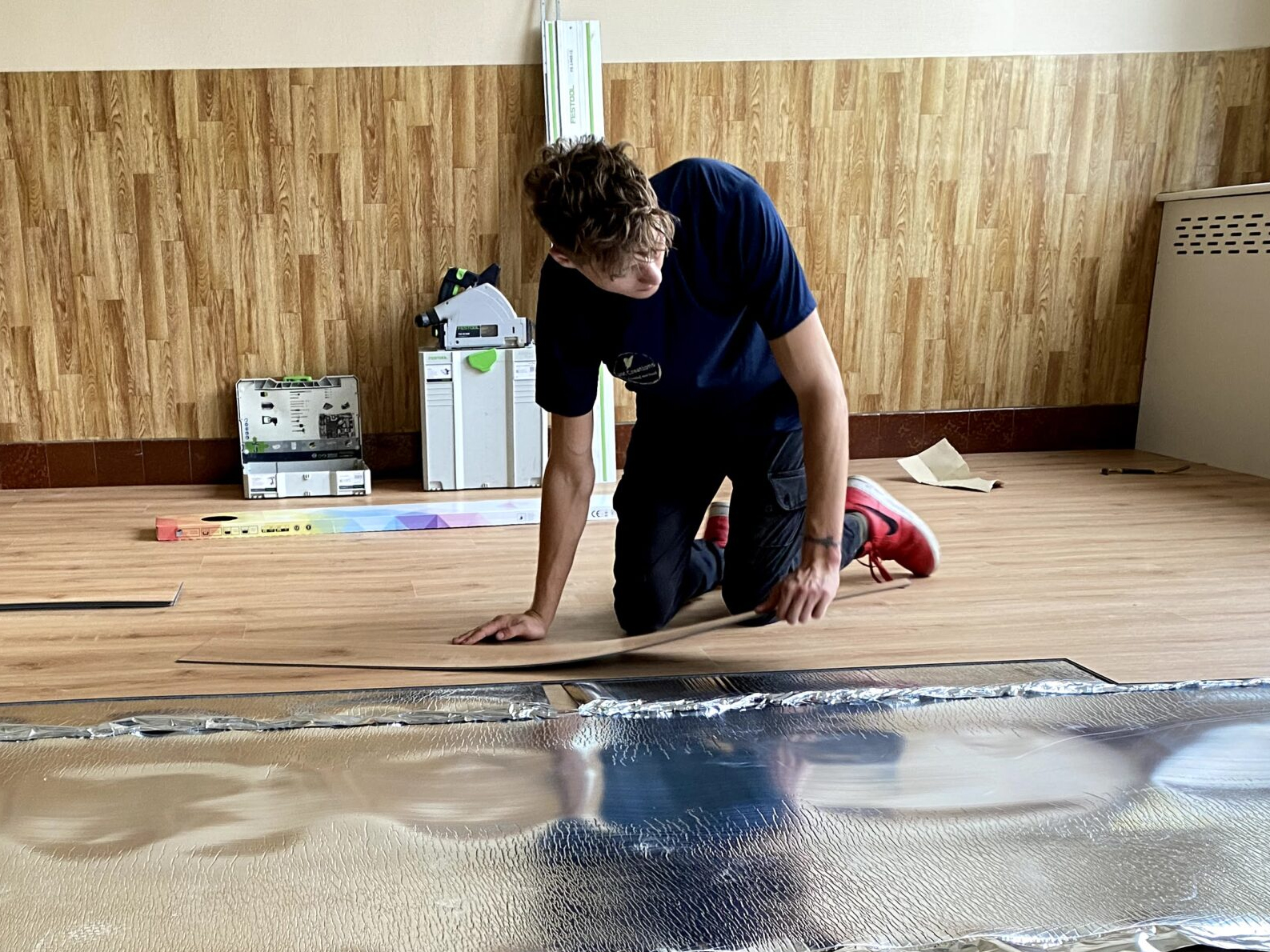 Jonge man die een parketvloer aanlegt